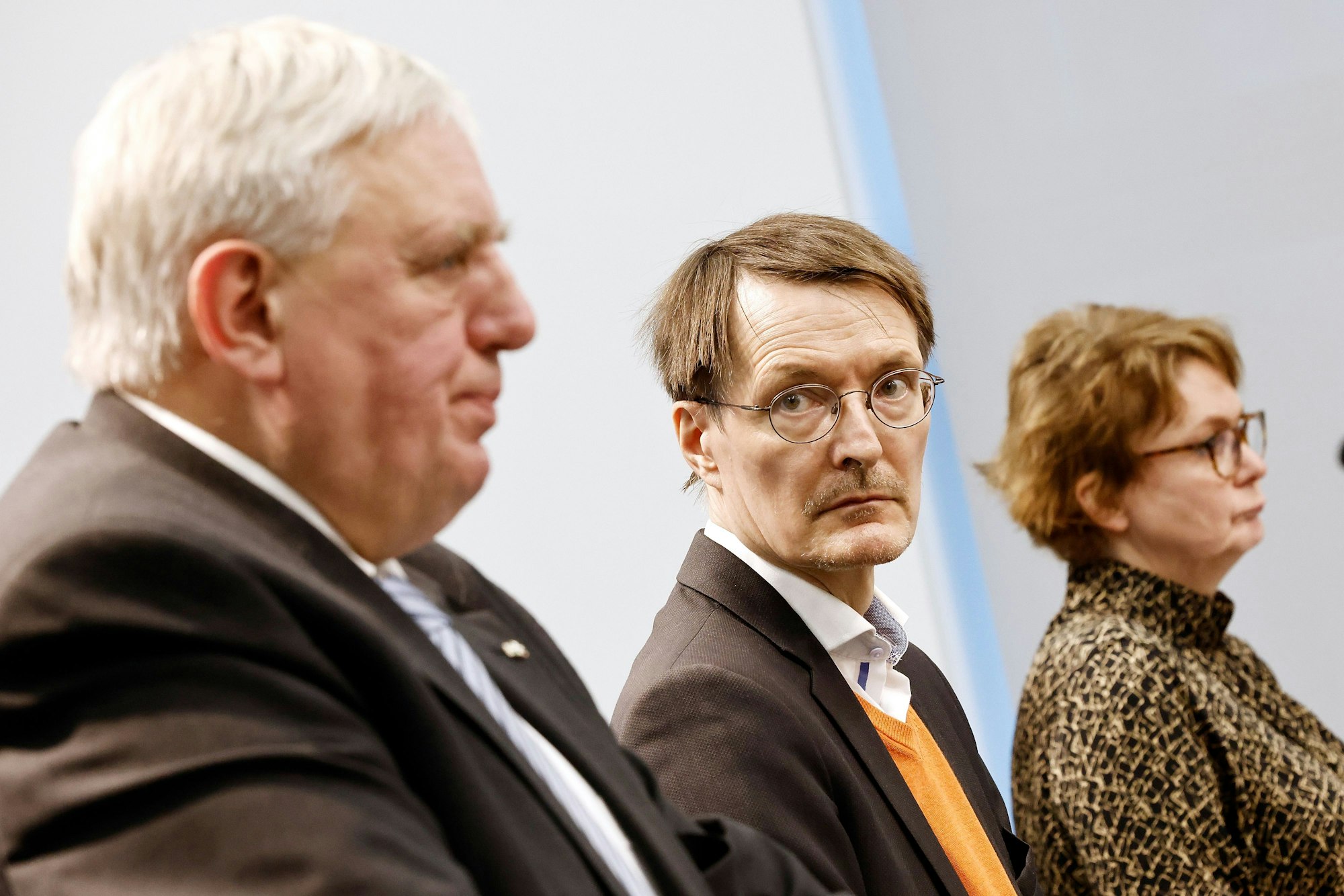 Links steht Laumann bei einer Pressekonderenz, sein Bild ist leicht verschwommen. Lauterbach steht rechts daneben, die Kamera fokussiert auf ihn. Lauterbach blickt auf Laumann.