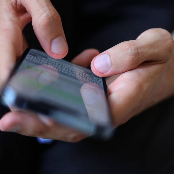 Ein junger Mann tippt auf einem Smartphone eine WhatsApp Nachricht.