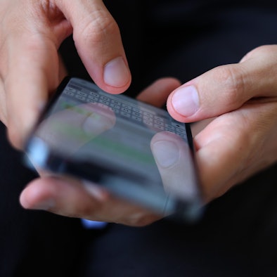 Ein junger Mann tippt auf einem Smartphone eine WhatsApp Nachricht.