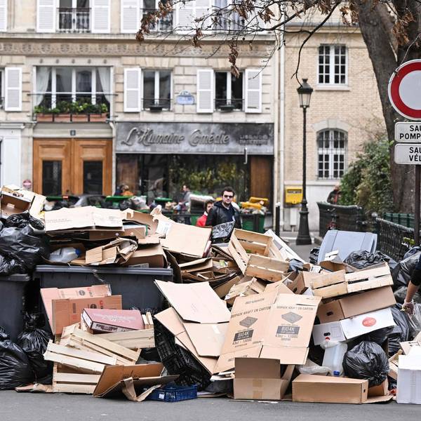 Müll stapelt sich auf und vor den Hausmüllcontainern in einer Pariser Straße.
