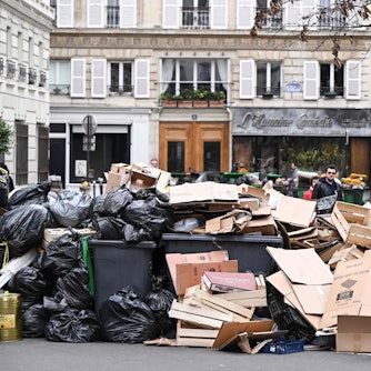 Müll stapelt sich auf und vor den Hausmüllcontainern in einer Pariser Straße.