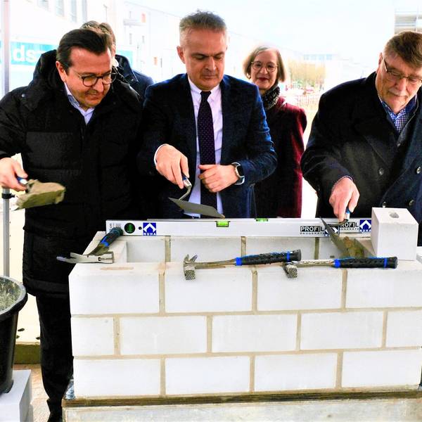 Grundsteinlegung mit weißen Steinen und Mörtel