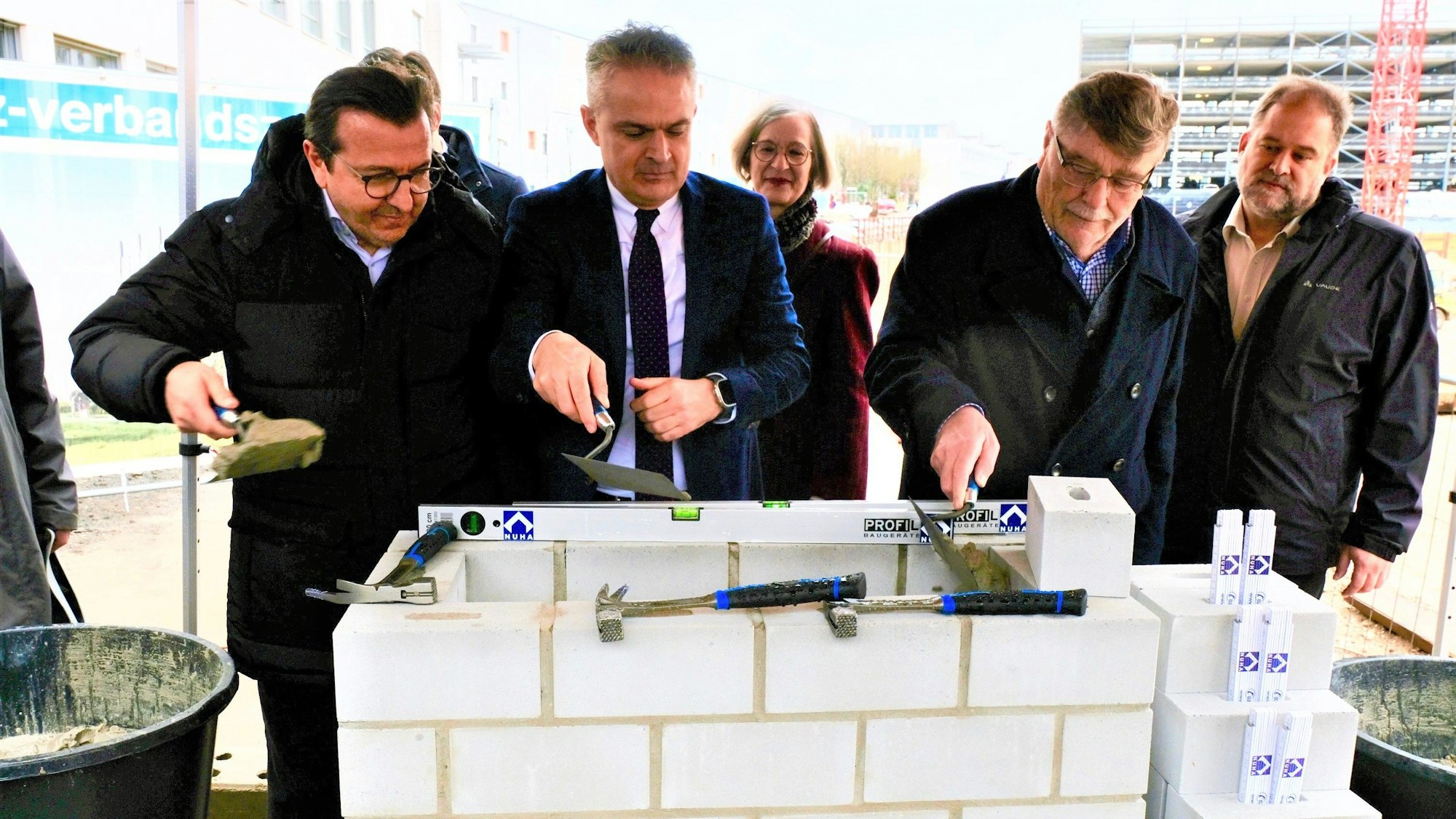 Grundsteinlegung mit weißen Steinen und Mörtel