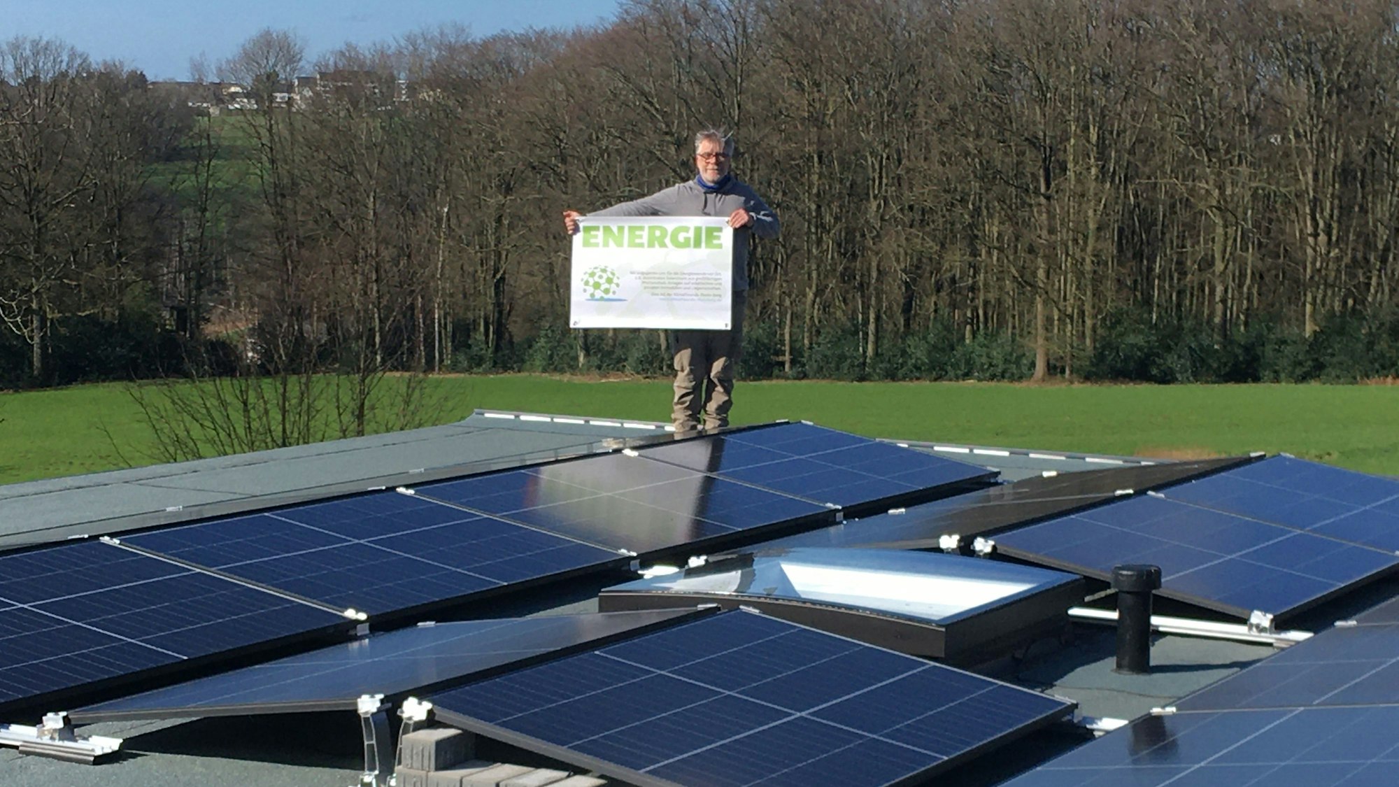 Stefan Häusler steht zwischen Solaranlagen auf einem Dach.