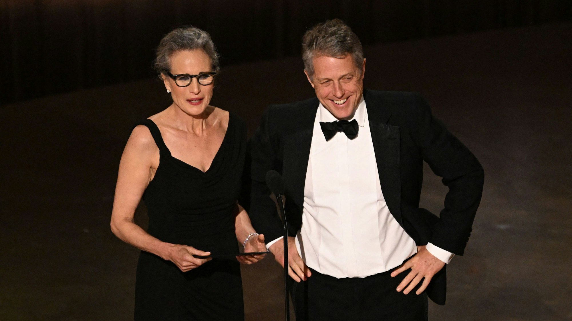Die US-Schauspielerin Andie MacDowell (l.) und der englische Schauspieler Hugh Grant sprechen auf der Bühne während der 95. jährlichen Oscar-Verleihung im Dolby Theatre in Hollywood, Kalifornien, am 12. März 2023.