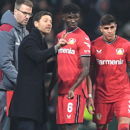12.03.2023, Bremen: Fußball: Bundesliga, Werder Bremen - Bayer Leverkusen, 24. Spieltag, wohninvest Weserstadion. Leverkusens Trainer Xabi Alonso (l) spricht an der Seitenlinie mit Odilon Kossounou und Piero Hincapie (r). Foto: Carmen Jaspersen/dpa - WICHTIGER HINWEIS: Gemäß den Vorgaben der DFL Deutsche Fußball Liga bzw. des DFB Deutscher Fußball-Bund ist es untersagt, in dem Stadion und/oder vom Spiel angefertigte Fotoaufnahmen in Form von Sequenzbildern und/oder videoähnlichen Fotostrecken zu verwerten bzw. verwerten zu lassen. +++ dpa-Bildfunk +++