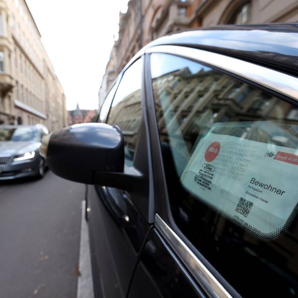 In einem Autofenster hängt ein Anwohnerparkausweis für das Belgische Viertel in Köln