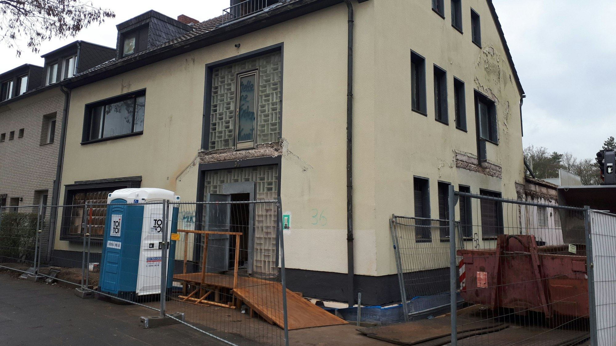 Reihenendhaus mit beigem Putz und Glasbausteinen