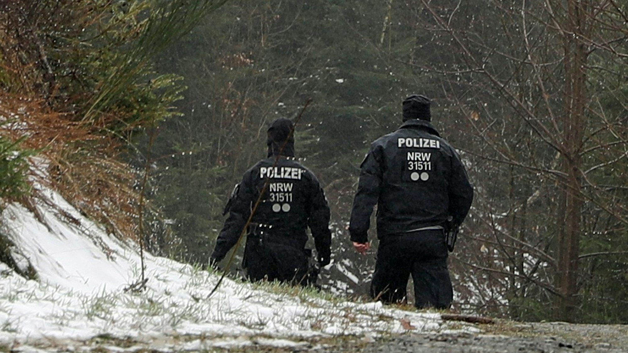 Freudenberg: Zwei Polizisten stehen in der Nähe des Fundorts einer Leiche.