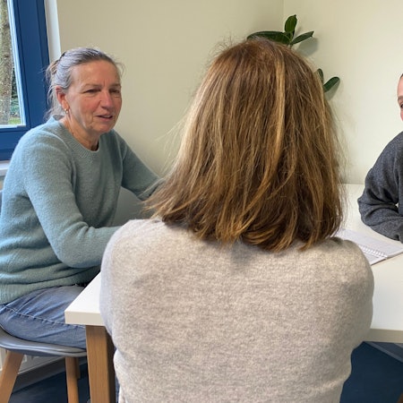 Im Schutzhaus sitzen die beiden Sozialarbeiterinnen Silvia Alt (l.) und Kristina Friedrichs (r.) mit einer Bewohnerin im Gespräch zusammen.