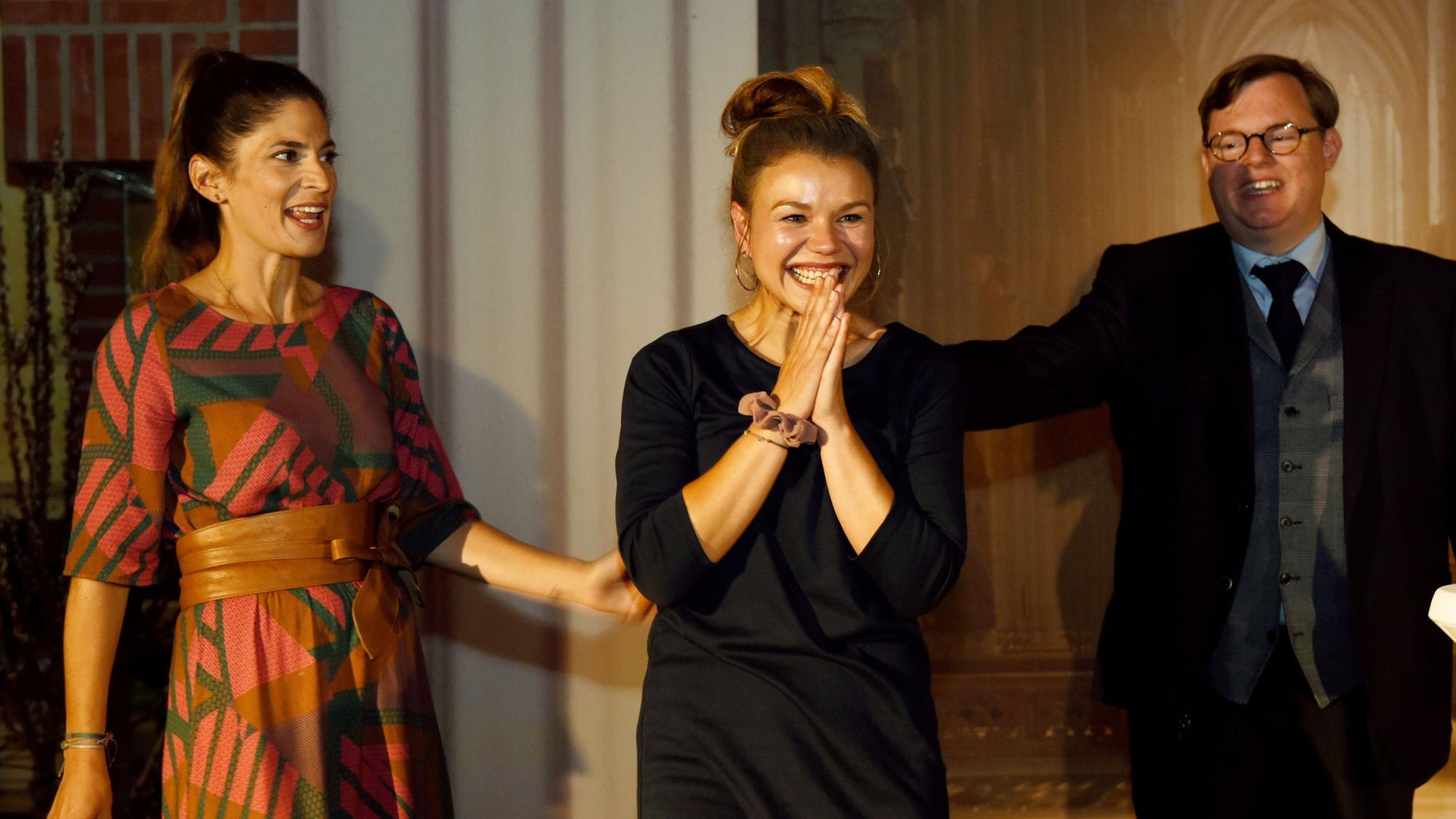 Köln Museum Ludwig Crime Cologne Krimifestival Award 2019 an Romy Hausmann v. li Katty Salie, Romy Hausmann und Mike Altwicker. Hausmann zeigt sich glücklich über ihren Sieg, lächelt und hat die Hände zusammengefaltet.