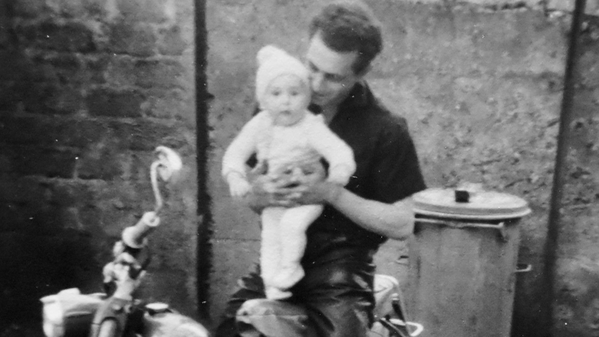 Willi Altenfeld stellt seinen ältesten Sohn Ralf als Kleinkind auf ein Motorrad.