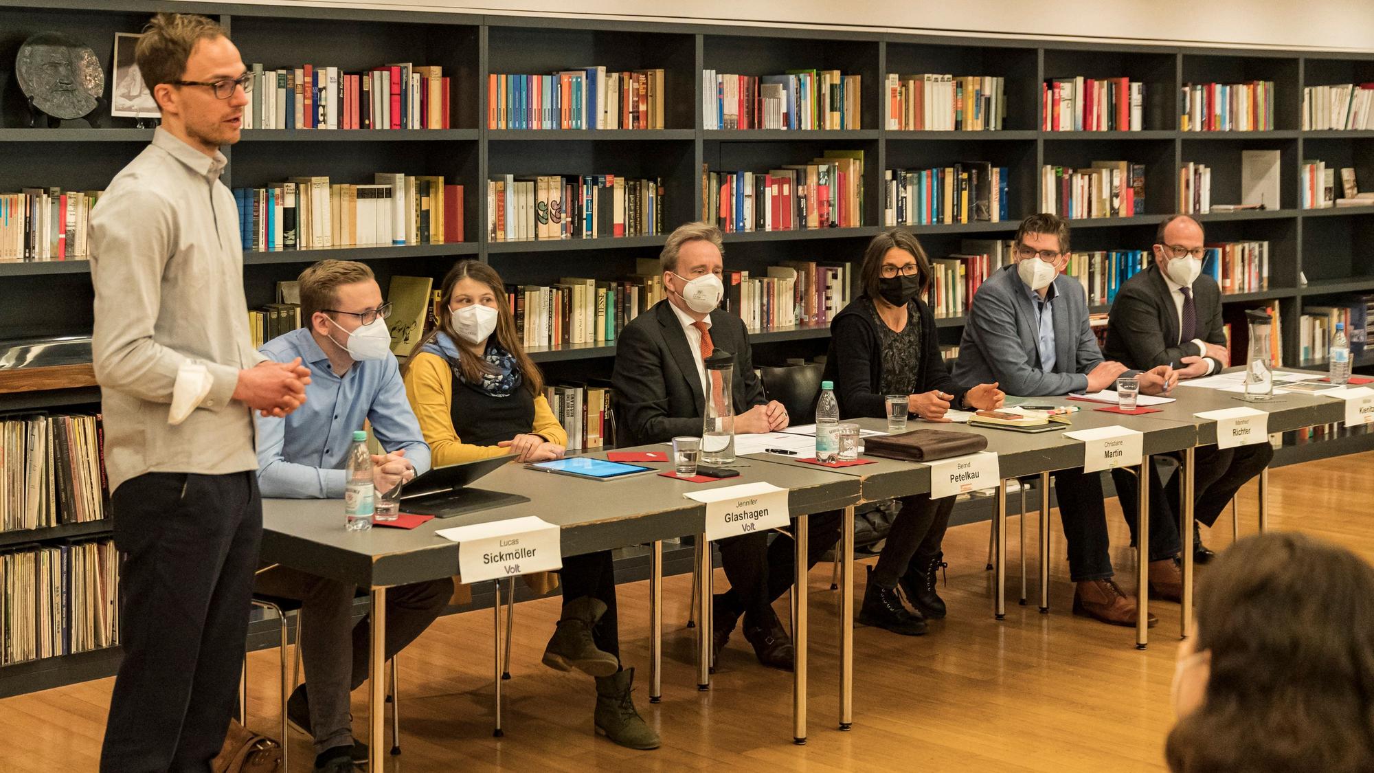 Das Bild zeigt mehrere Politiker des Ratsbünndnisses, die an einem Tisch sitzen.