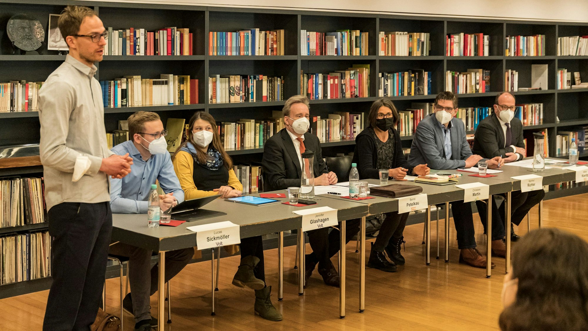 Das Bild zeigt mehrere Politiker des Ratsbünndnisses, die an einem Tisch sitzen.