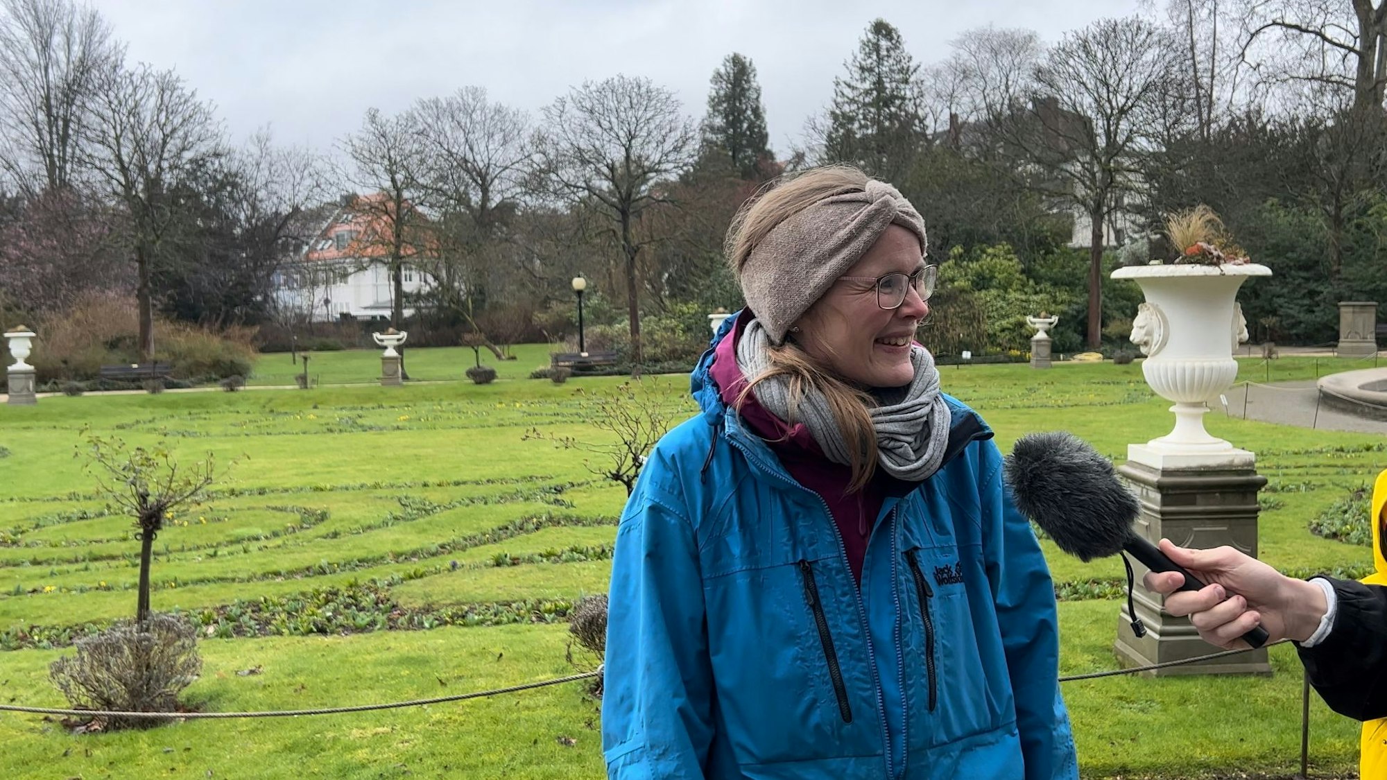Eine Frau steht in einem Park.