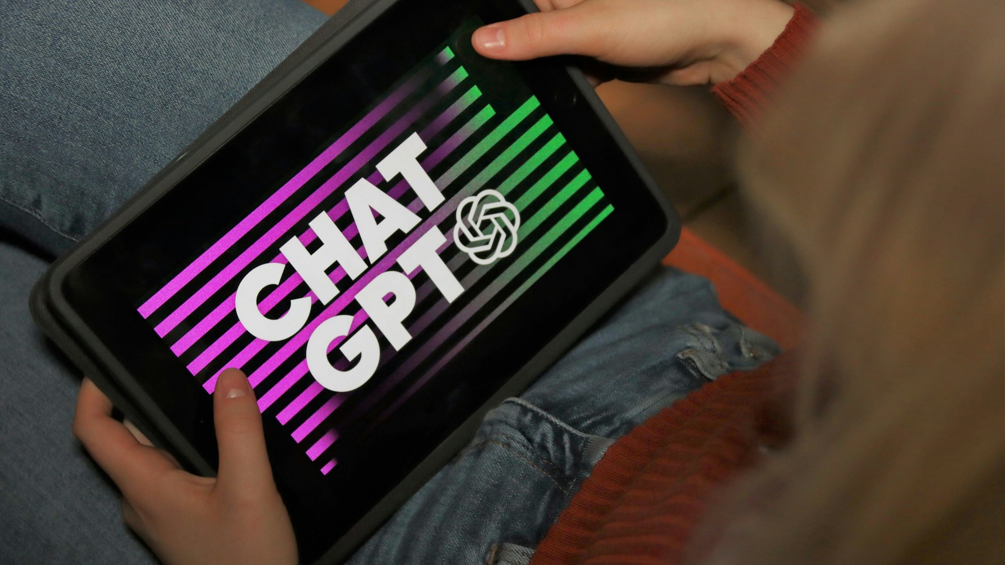 Eine Person gibt am Tabelt etwas in das Programm ChatGPT ein.