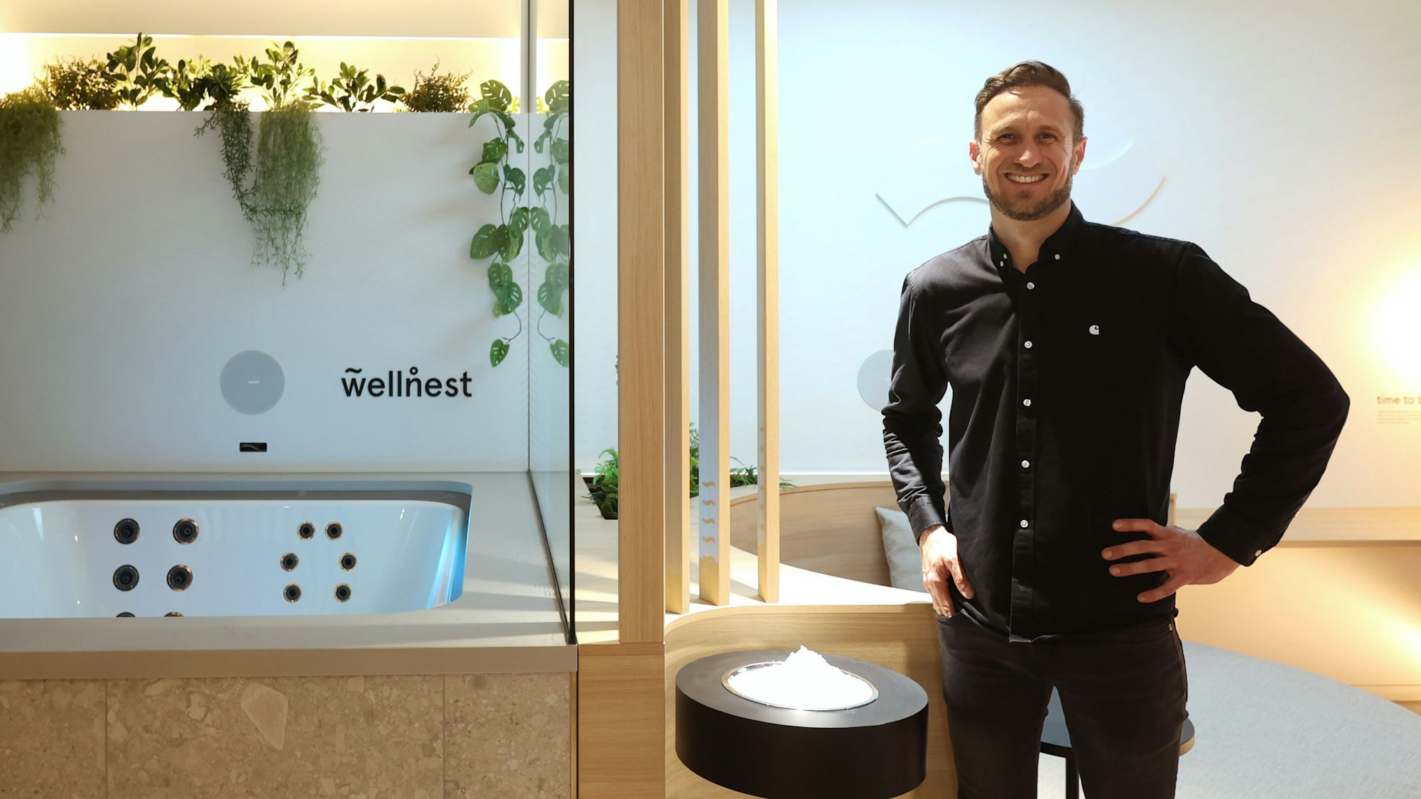 Marc André Pfeiffer steht in einem der Spa-Zimmer. Neben ihm ist ein Whirlpool zu sehen.