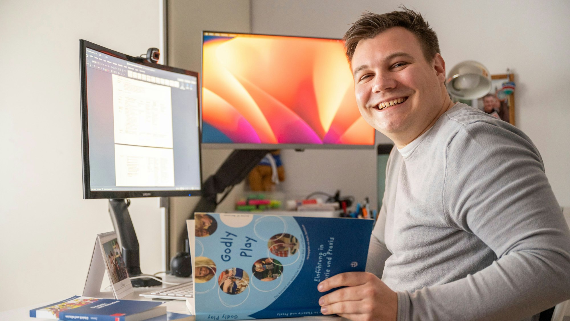 Moritz Bonenkamp trägt einen grauen Pulli und blättert in einem Englischbuch.