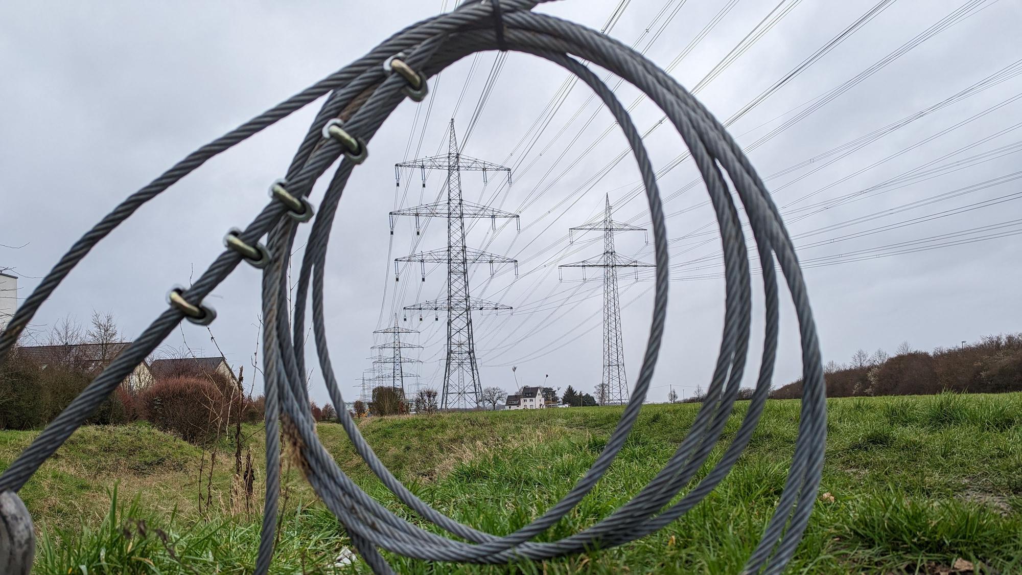 In Hürth beschweren sich Anwohner über peitschende Geräusche von den im Bau befindlichen Hochspannungsmasten. Das Foto zeigt Stahlkabel und im Hintergrund die Masten.