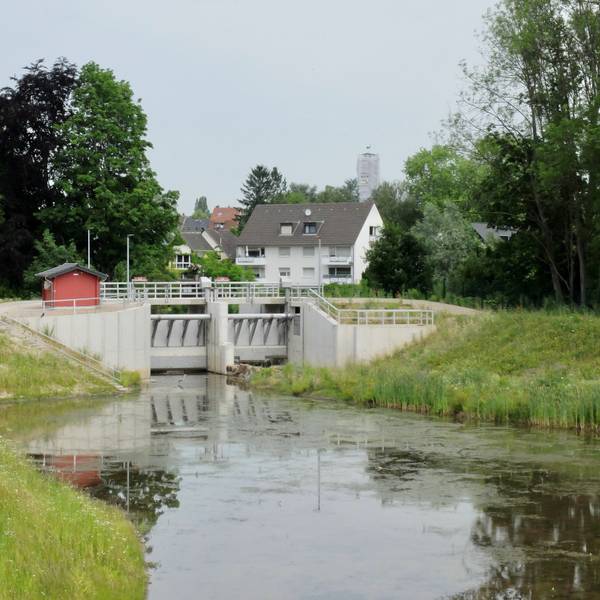 Hinter dem Hochwasserbecken und Schleuse Kippemühle in Bergisch Gladbach-Gronau liegen Häuser.