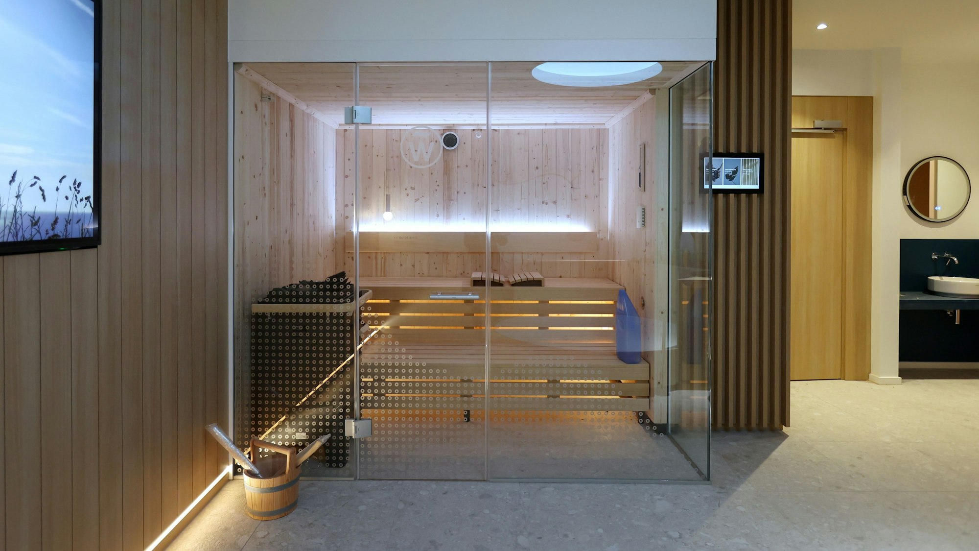 Zu sehen ist die Sauna, abgetrennt durch eine Glasfront.