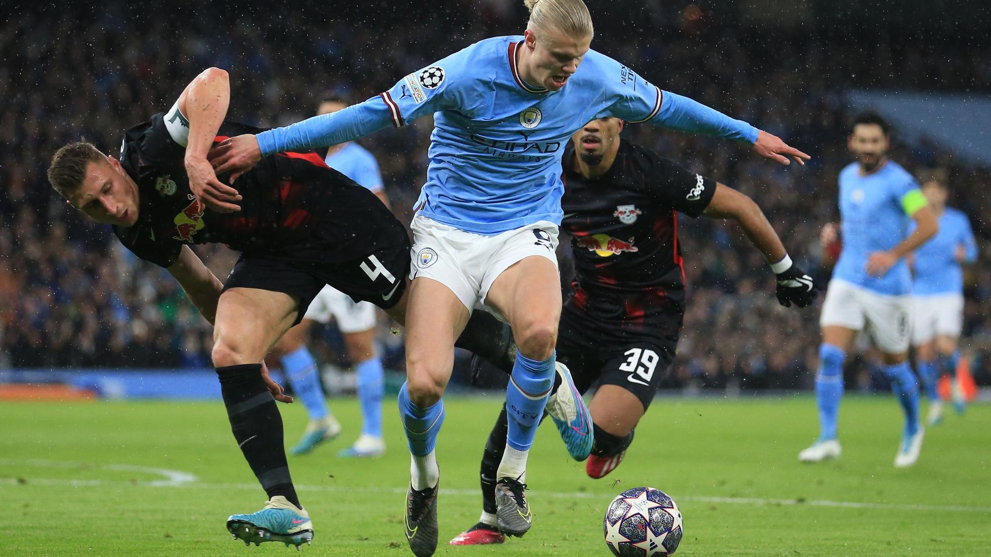 Leipzigs Willi Orban und Benjamin Henrichs in Aktion gegen Manchester Citys Erling Haaland.