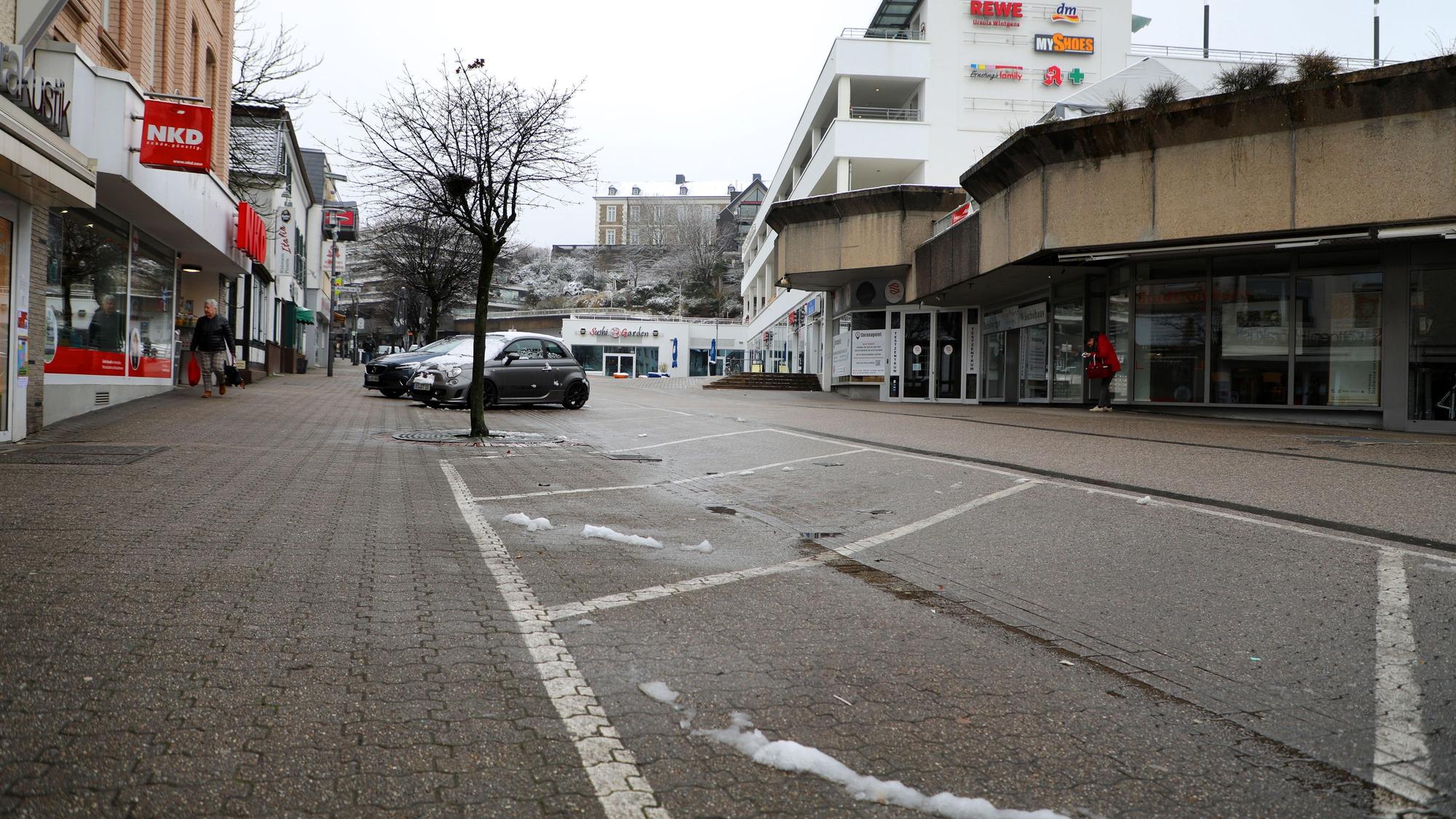 Im Vordergrund befinden sich mehrere freie Parktaschen, im Hintergrund sind die Schlossgalerie an der Schloßstraße sowie am Horizont das Schloss Bensberg zu sehen.