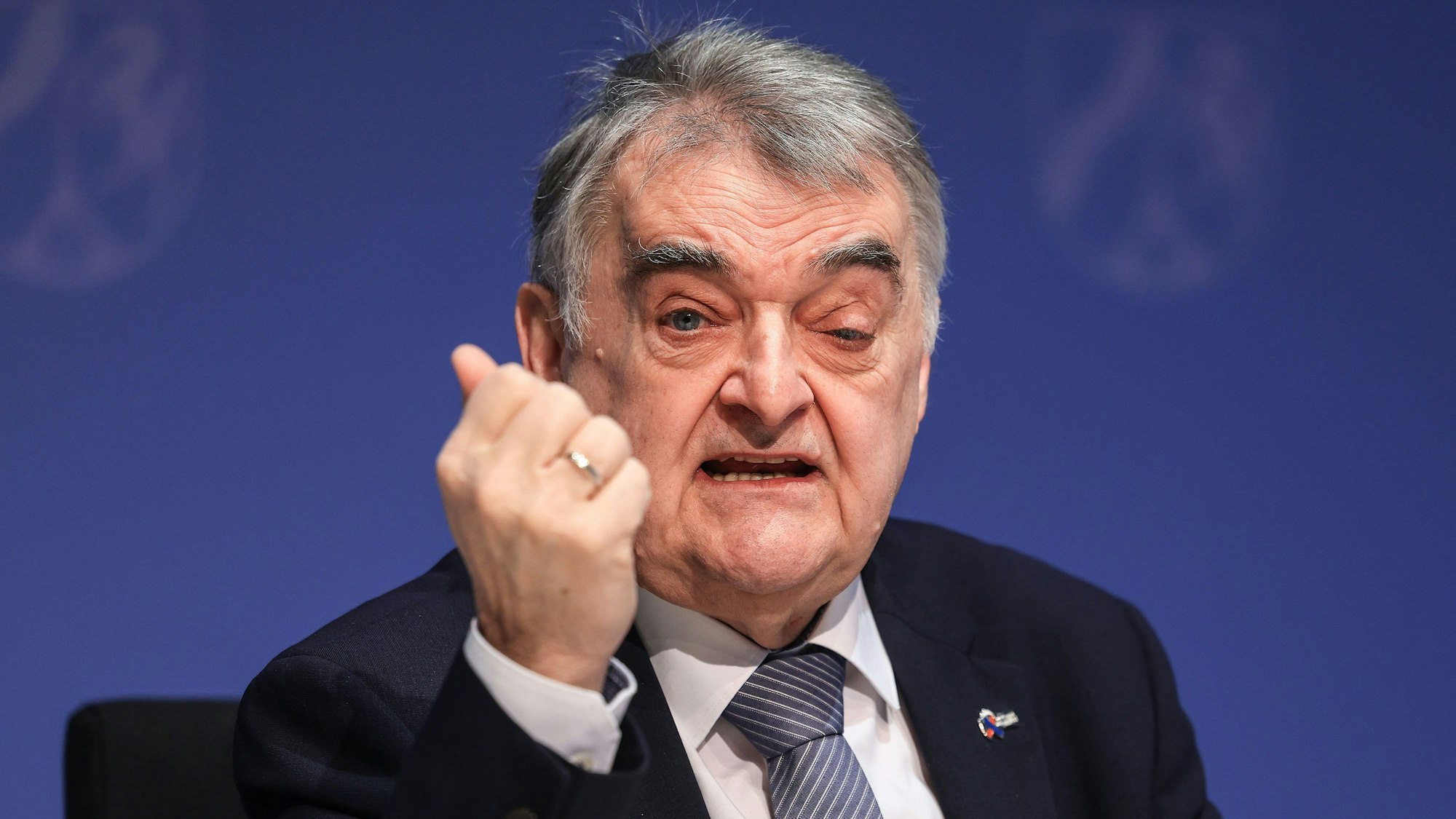 Herbert Reul sitzt auf einem Bürostuhl und ballt eine Faust