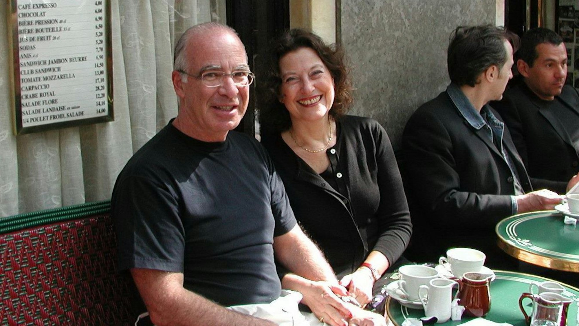 Gabriel Gorodetsky und Ruth Herz sitzen in einem Café in Paris und lächeln.