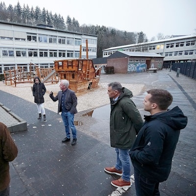 Schulleiter Wolfgang Schmitz und die Mitglieder des Ausschusses stehen auf dem Schulhof der Astrid-Lindgren-Förderschule.