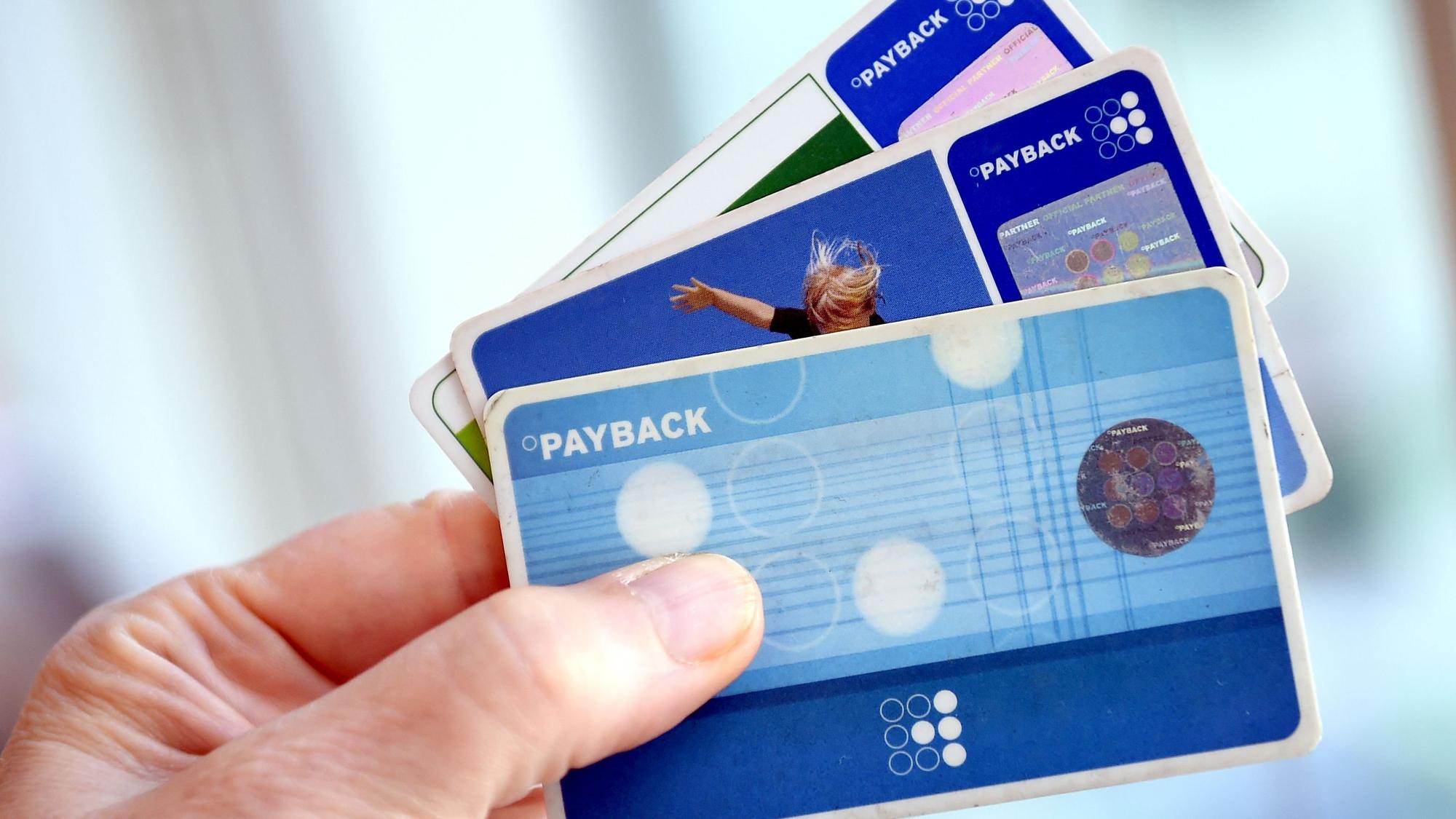 Eine Person hält Karten des Bonussystems Payback.