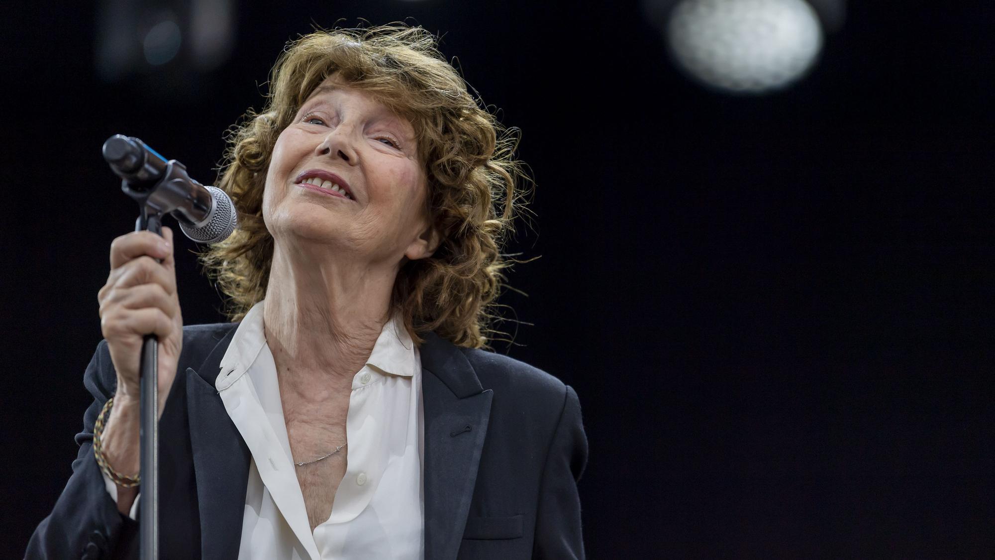 Jane Birkin bei einem Konzert am Mikrofon.