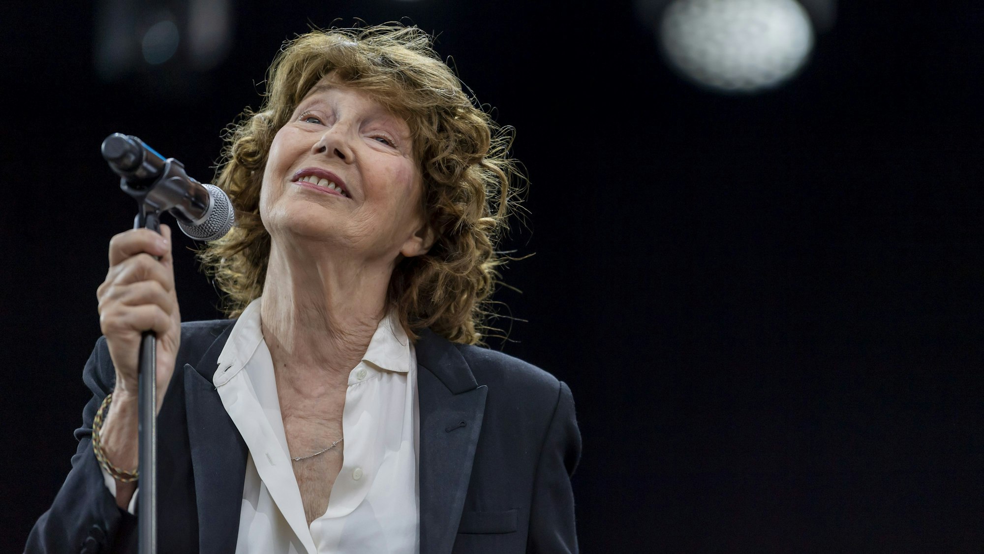 Jane Birkin bei einem Konzert am Mikrofon.