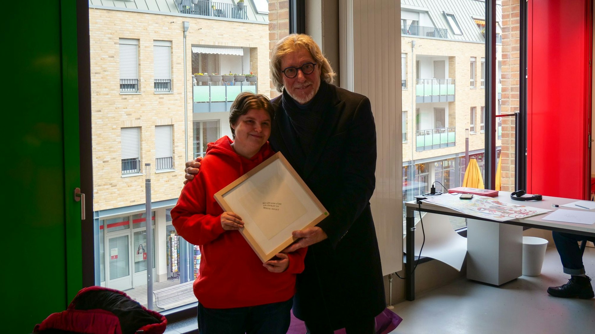 Das Foto zeigt Nicole Fellmann und Toni Schumacher. Sie schenkte der Torwart-Legende ein von ihr geschriebenes Gedicht in einem Bilderrahmen.