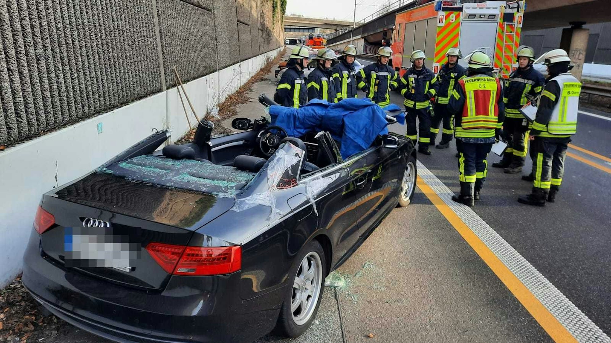 Mehrere Einsatzkräfte stehen vor einem Wagen, an dem sie das Dach hatten entfernen müssen, um eine Person zu befreien.