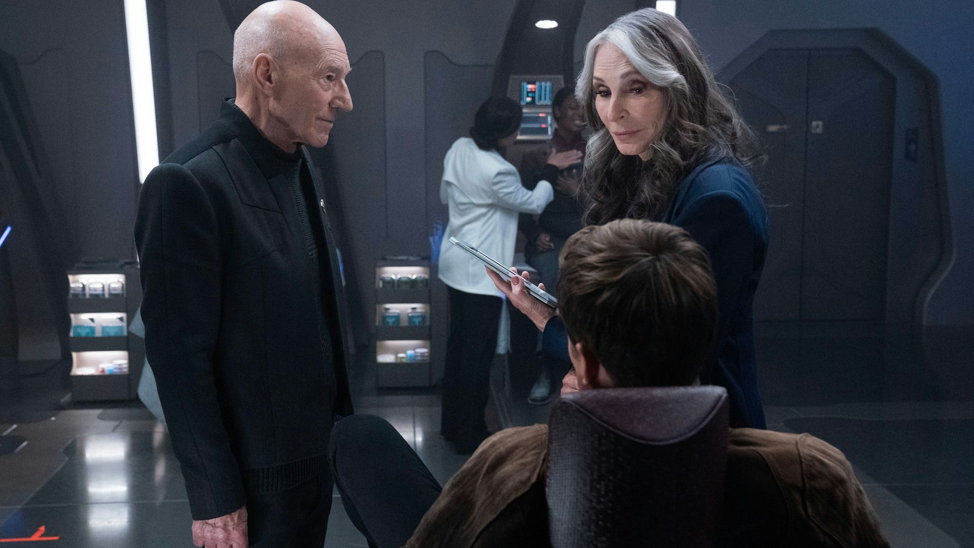 Patrick Stewart und Gates McFadden sind in einer Unterhaltung.