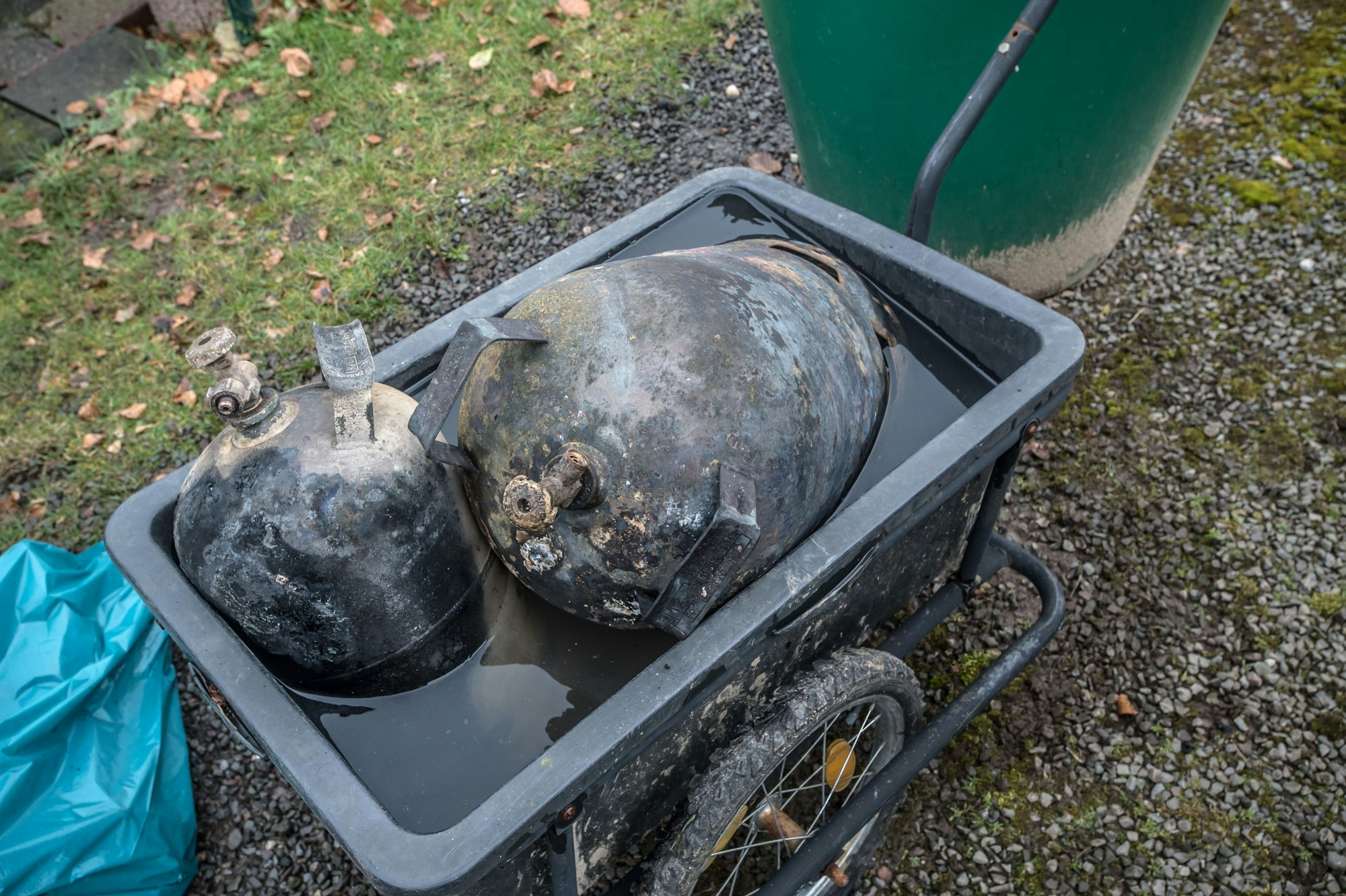 Gasflaschen liegen nach dem Feuer in einem Wasserbad. Hinter Gasthof Kaup, Freizeitplatz am Schnorrenberg. Foto: Ralf Krieger