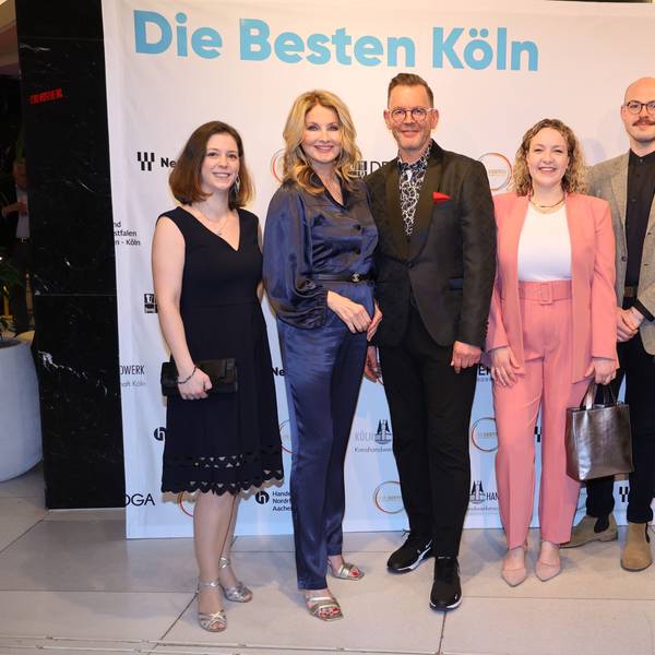 Preisträger und Veranstalter lächeln in die Kamera.