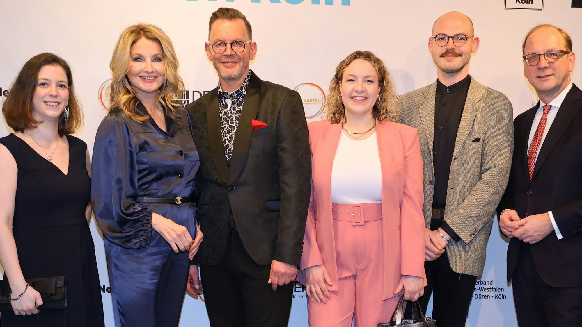 Preisträger und Veranstalter lächeln in die Kamera.