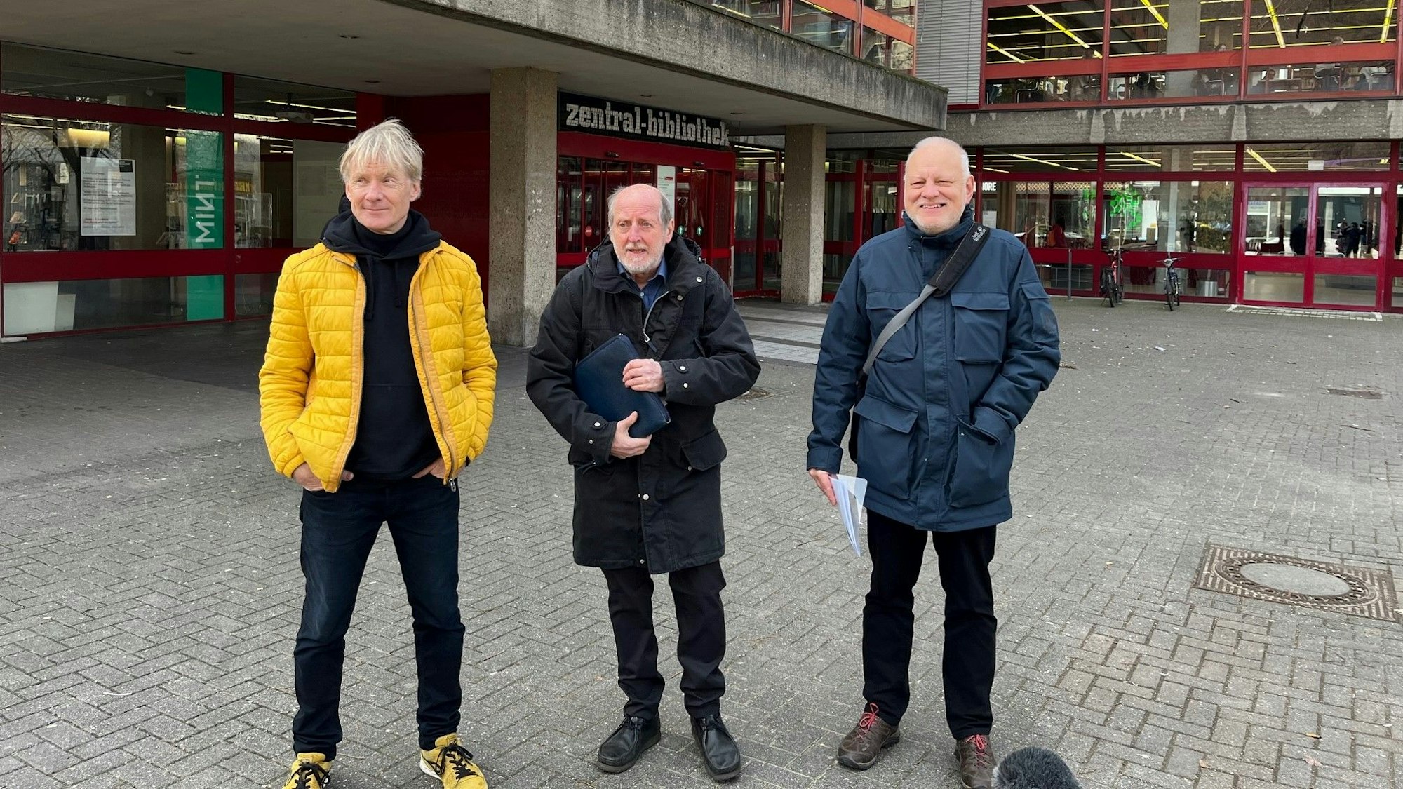 Thomas Baumgärtel, Helmut Röscheisen
und Jörg Frank stehen vor der Zentralbibliothek am Neumarkt.