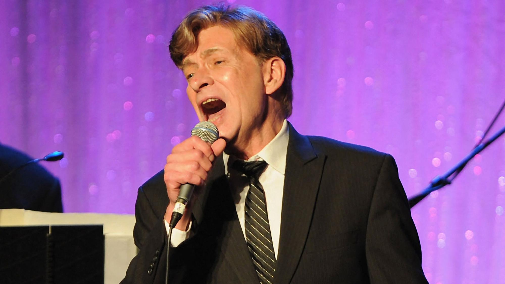 Bobby Caldwell singt in ein Mikrofon.