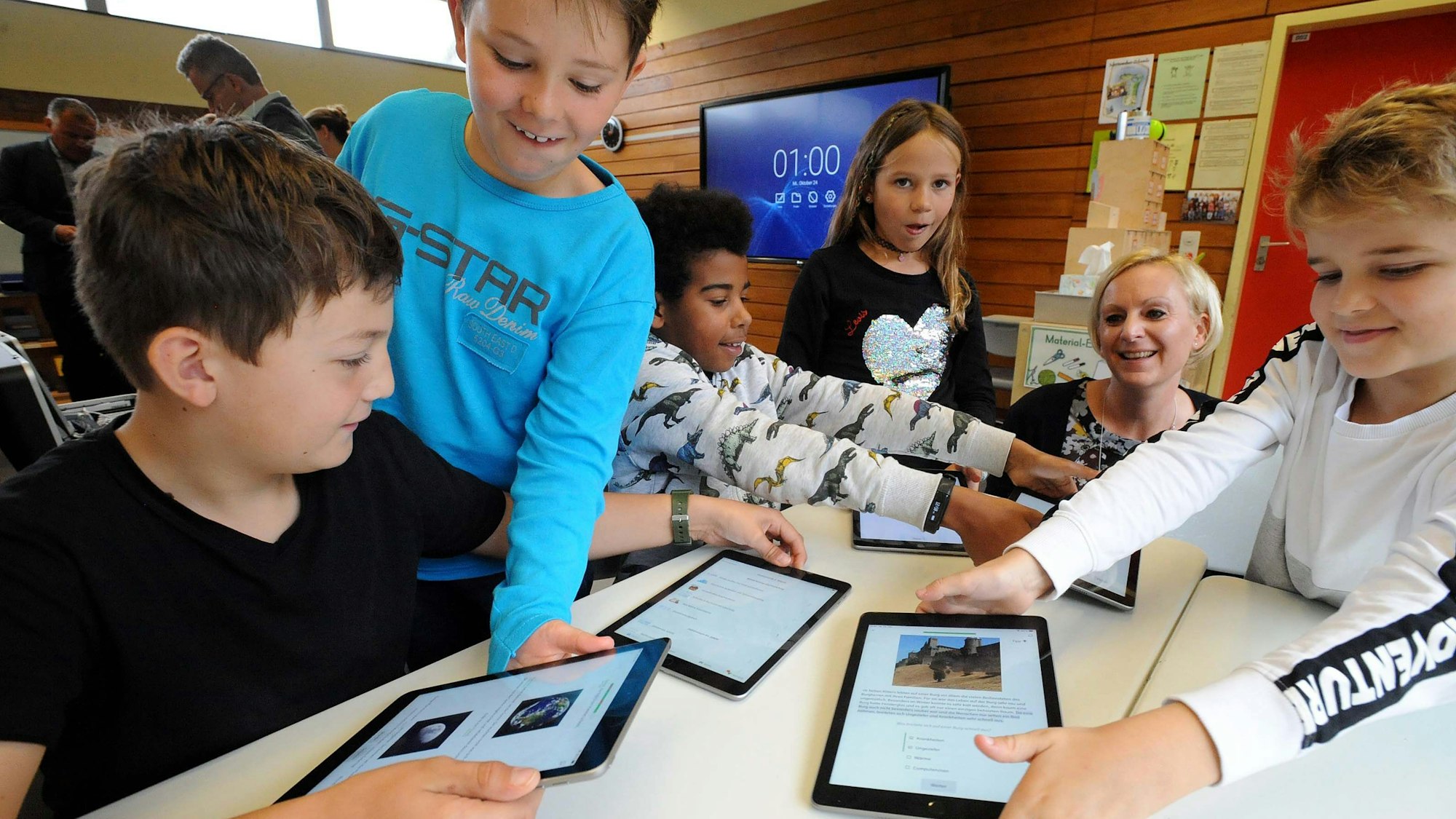 Schulkinder mit iPads im Unterricht.