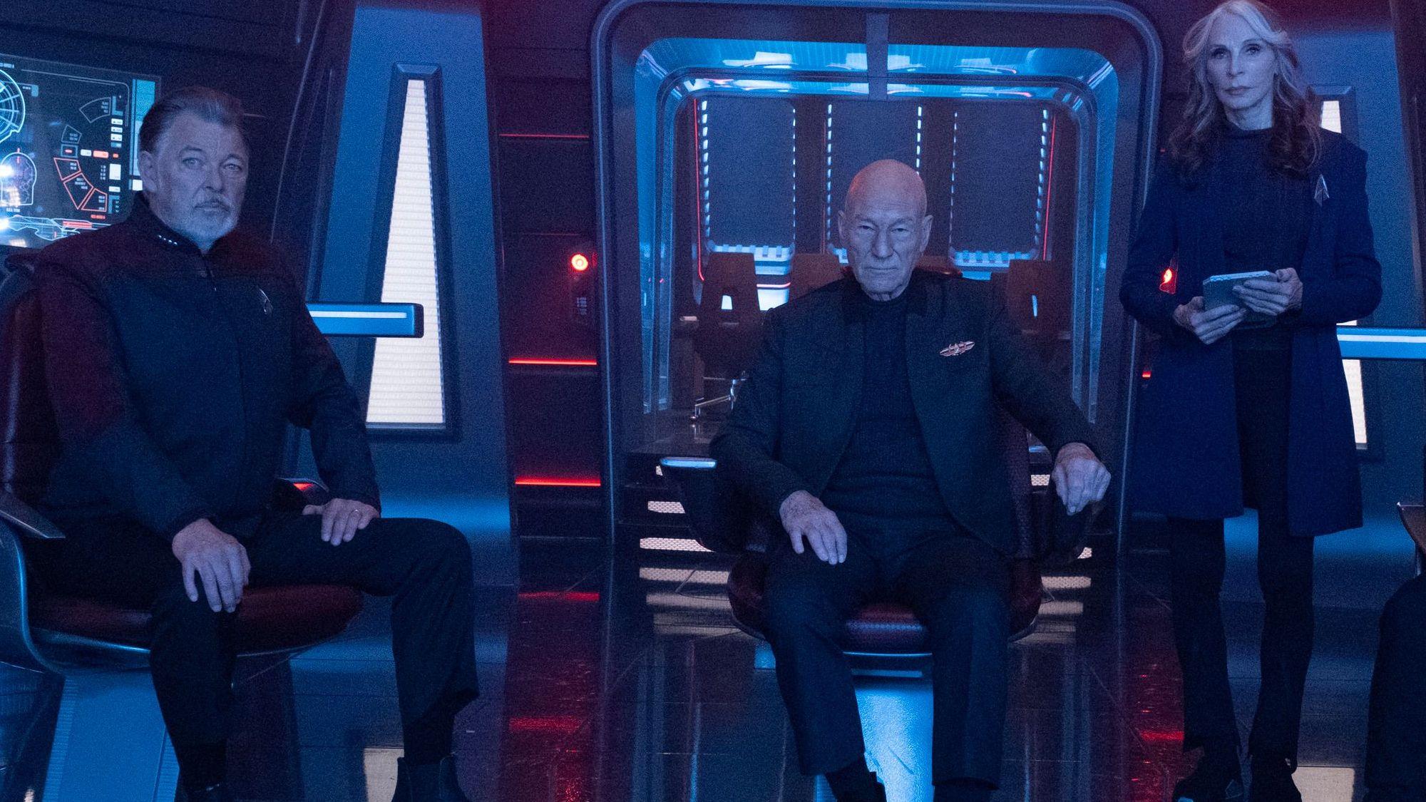 Joanthan Frakes, Patrick Stewart und Gates McFadden sind auf der Brücke eines Raumschiffes.