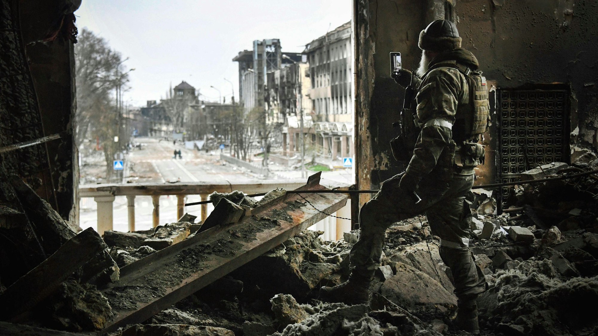 (FILES) In this file photo taken on April 12, 2022 A Russian soldier patrols at the Mariupol drama theatre, bombed last March 16, in Mariupol, as Russian troops intensify a campaign to take the strategic port city, part of an anticipated massive onslaught across eastern Ukraine, while Russia's President makes a defiant case for the war on Russia's neighbour. - *EDITOR'S NOTE: This picture was taken during a trip organized by the Russian military.* (Photo by Alexander NEMENOV / AFP)