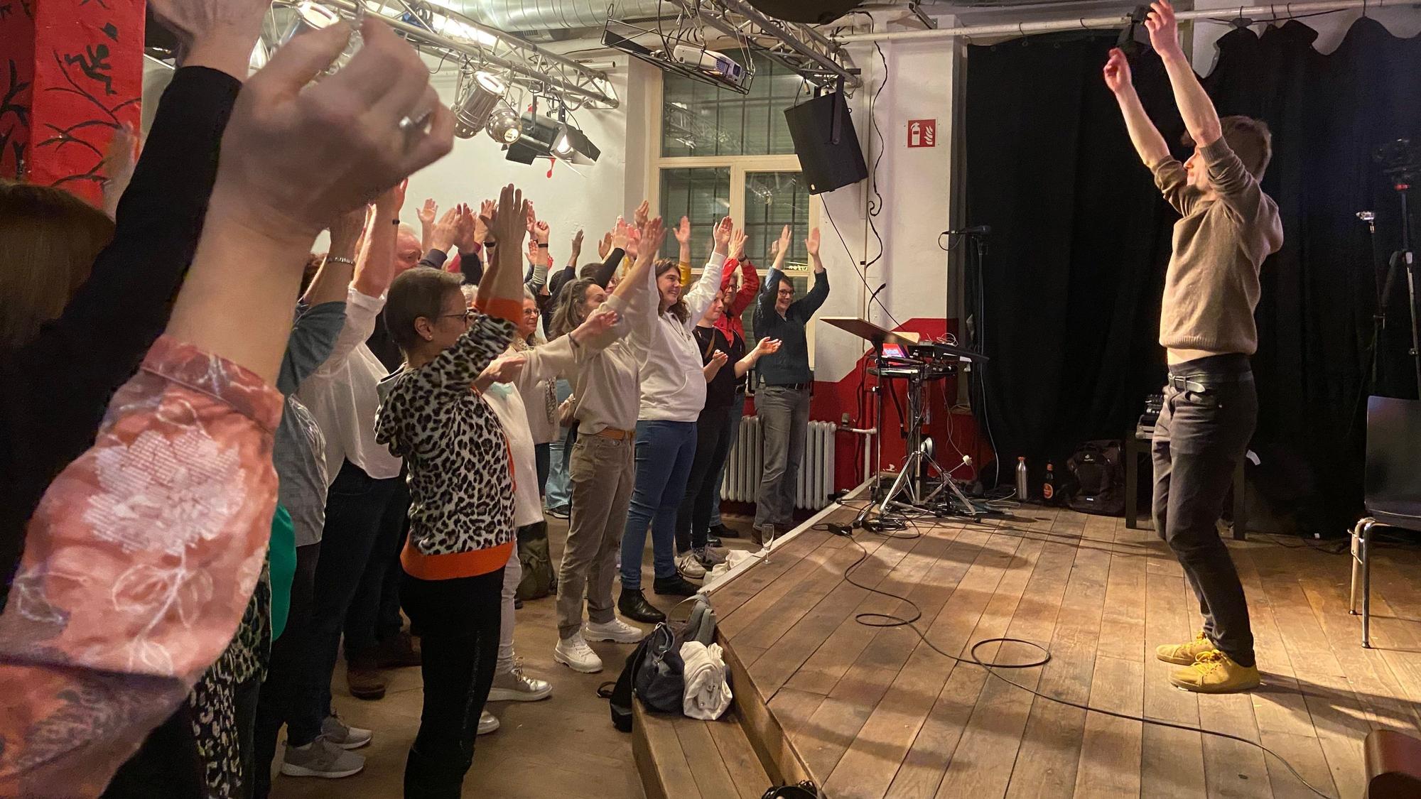Das Publikum im Scala-Club in Opladen singt sich ein und hebt die Hände.