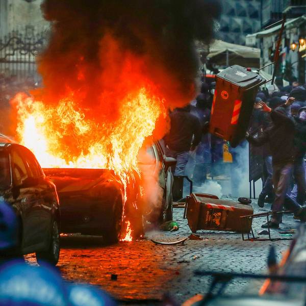 Vermummte Hooligans randalieren vor dem Spiel auf einer Straße in Neapel.