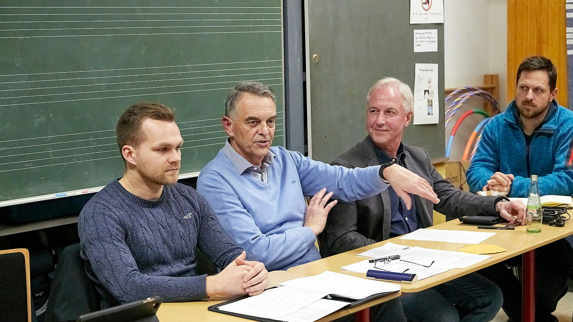 Verbandsvorsteher Rudolf Westerburg sitzt mit drei anderen Männern an einem Tisch.