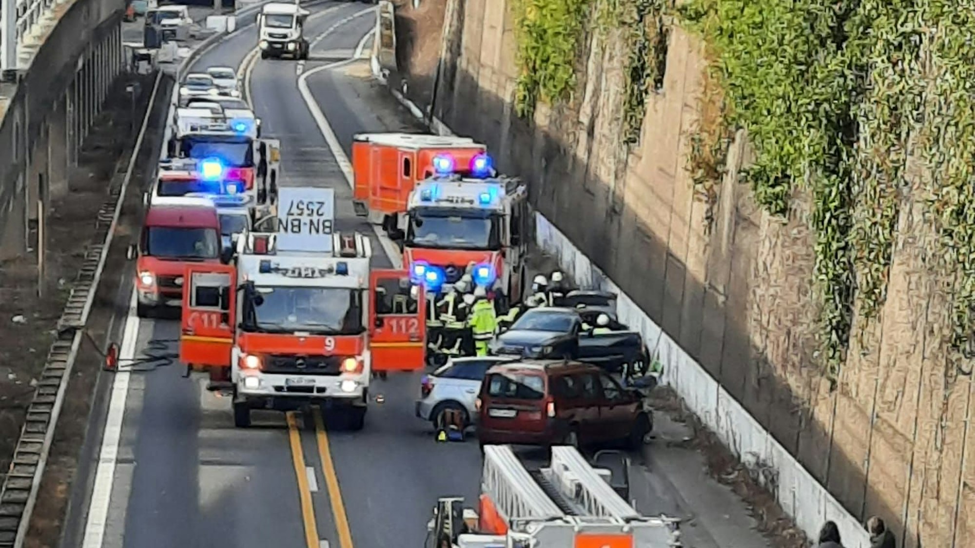 Mehrere Einsatzfahrzeuge der Feuer stehen auf einer komplett gesperrten Straße.