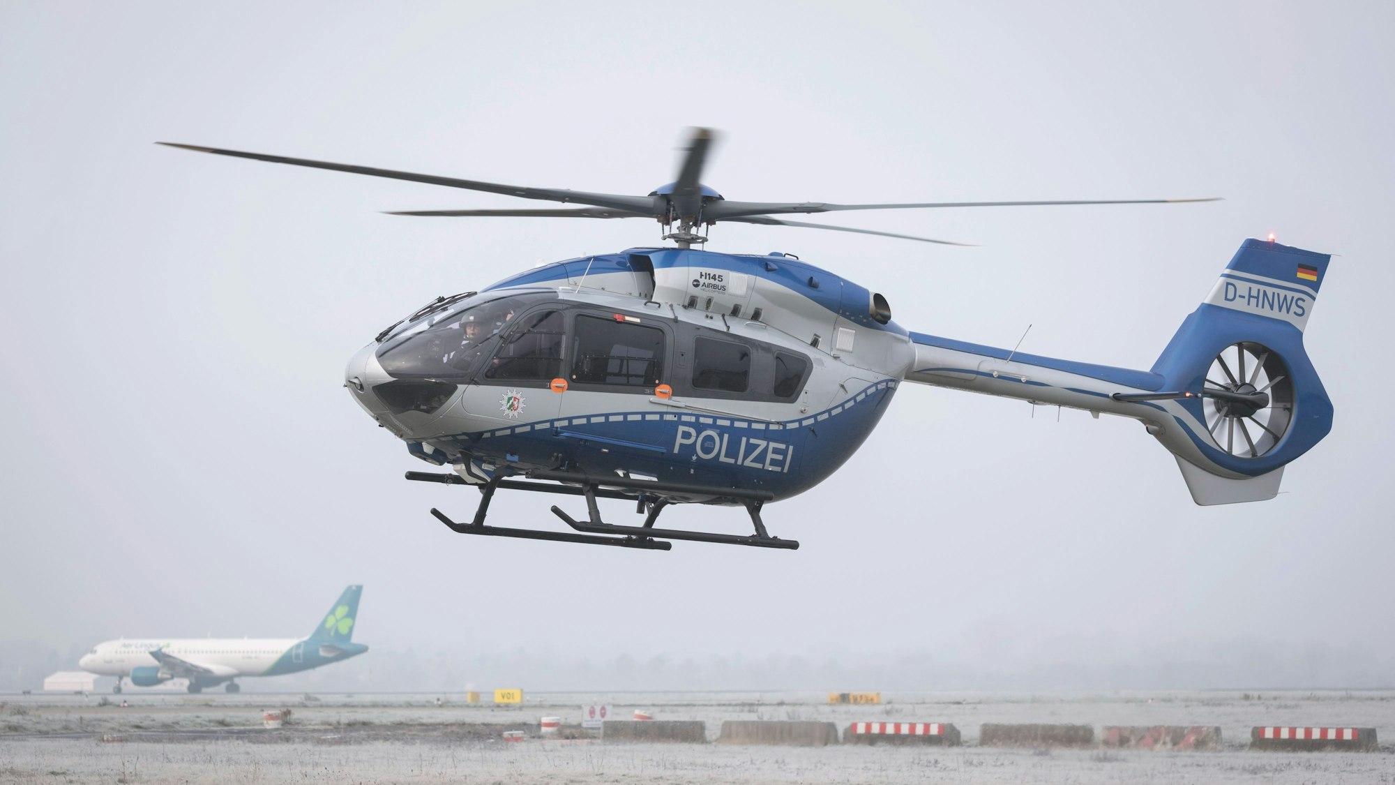 Ein blau-silberner Polizeihubschrauber im Einsatz.