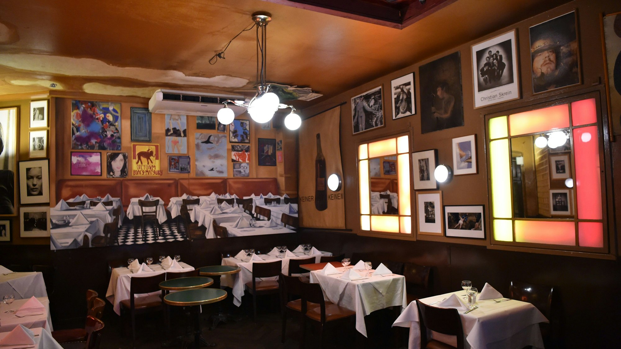 Gedeckte Tische und Kunst an den Wänden: Der Innenraum der „Paris Bar“ in Berlin-Charlottenburg besticht durch besonderes Flair.